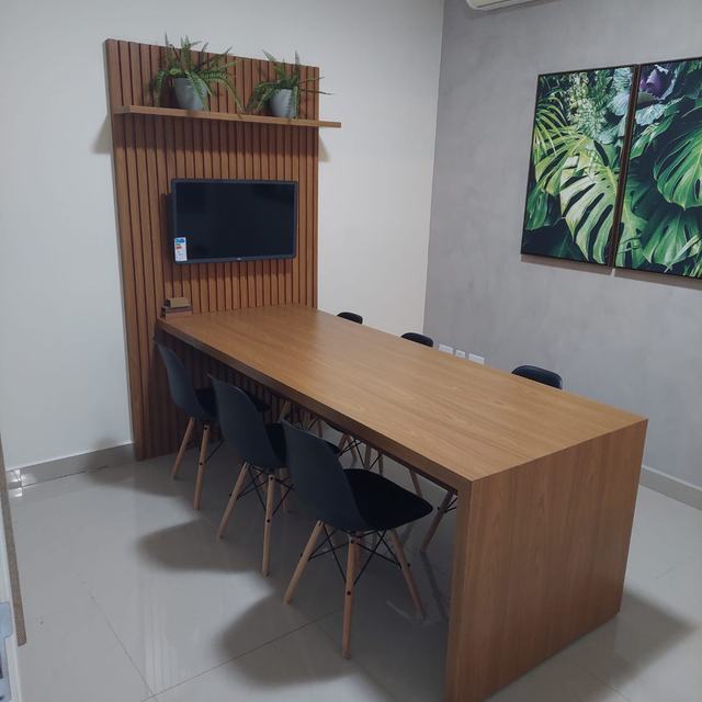 Sala de reunião com painel ripado e mesa